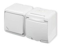 JUNIOR Łącznik schodowy z gniazdem hermetycznym (klapka biała)